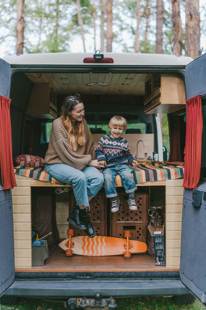 woman on her phone in front of a parking lot full of a variety of cars